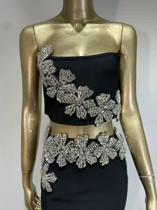 Detalle del bordado de flores de strass sobre un conjunto de fiesta de dos piezas negro