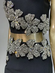 Detalle de bordados florales con pedrería en un conjunto de fiesta negro de dos piezas