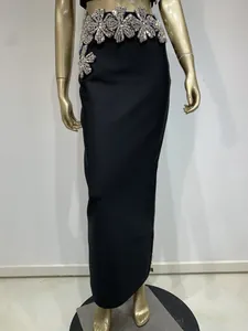 Detalle de falda bandage negra de cintura alta con decorado de flores de diamantes