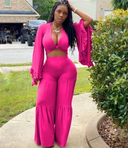 Sexy pink two-piece set with long bell-sleeve crop top and wide-leg trousers