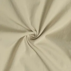 Close-up of soft beige fabric texture with a central swirl for plus size apparel