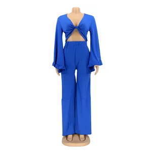 Close-up of blue long-sleeve two-piece set featuring flared pants and tie-front top.
