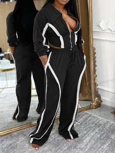 Detail view of women's black and white two-piece sports set featuring cropped zip jacket