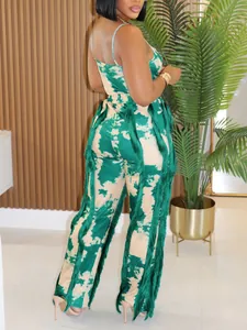 Close-up detail of a green and beige tie-dye two-piece set with long fringe accents on pants