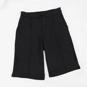Vista detallada de alta calidad de pantalones cortos negros de traje con pliegues y bolsillos