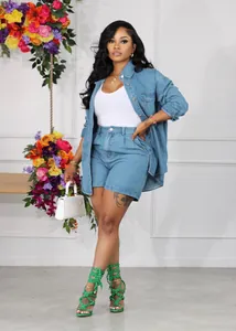 Modèle portant un ensemble veste et short en denim bleu avec talons verts et sac blanc.