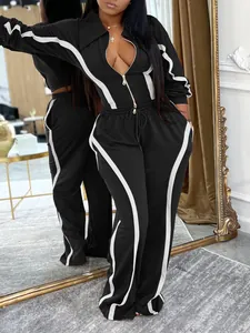 Close-up of black two-piece sports set with white stripe details and zip jacket