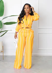 Close-up detail of a vibrant yellow and white striped shirt and wide-leg trousers set on model