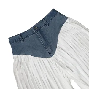 Detail shot of denim patchwork wide-leg trousers with white pleated fabric texture.