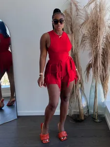 Model wearing red fringe two-piece set with ribbed tank top and shorts in a home setting