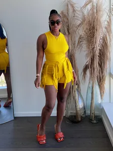 Two-piece summer set featuring a yellow sleeveless top and fringe-trim shorts