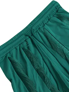 Close-up detail of teal fringe tassels on the elastic waistband of a solid color short set.