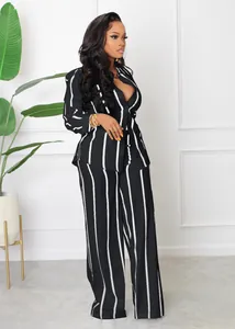 Full length shot of model wearing a black and white striped shirt and matching wide-leg trousers