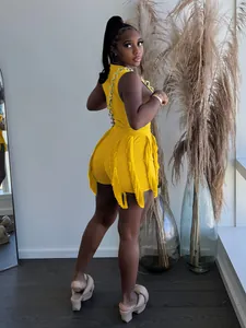 Detailed side view of yellow two-piece summer set with fringe shorts and chain trim