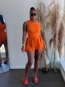 Model wearing orange two-piece set featuring fringe trim tank top and matching shorts