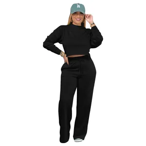A detailed view showing the black cropped sweatshirt paired with wide-leg sports sweatpants