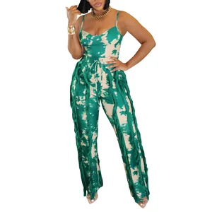 Detailed view of women's green tie-dye two-piece summer outfit with fringe trim pants