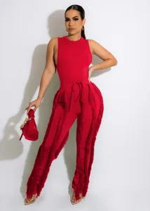 Elegant model in een felrode tweedelige outfit met een zeer stijlvolle franje broek