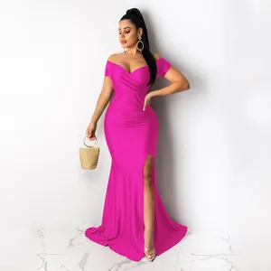 Détail d'une robe de soirée sexy rose fuchsia avec décolleté en V et fente haute.