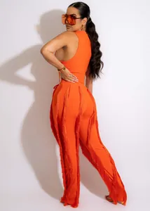 Zijaanzicht van de oranje tweedelige set met lange franjes aan de zijkant van de broek