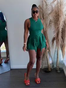 Detailed view of a vibrant green two-piece outfit featuring a fringe tank top and shorts.
