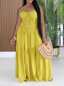 A full-length view of a bohemian mustard yellow tiered maxi dress with flowy texture.