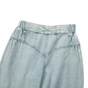 Detail shot of light wash high-waisted denim jeans featuring an elastic waistband