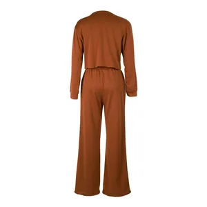 Back view of women's two-piece lounge set with long sleeve top and wide leg pants in rust