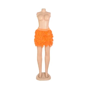 Front view detail of an orange turkey feather mini skirt displayed on a full-body mannequin.