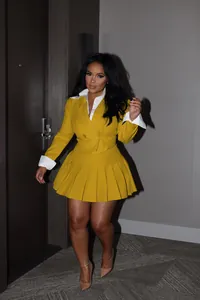 Stylish yellow blazer and pleated skirt two-piece set for professional office wear.
