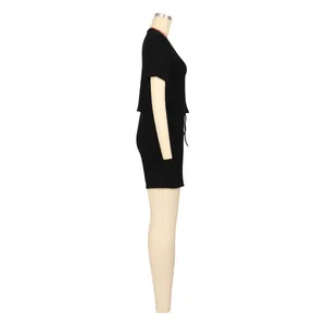 Vista laterale del set sportivo da donna nero in due pezzi con t-shirt a maniche corte e pantaloncini