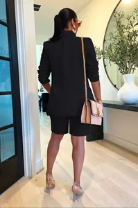 Vista posterior de un elegante conjunto negro de dos piezas con blazer y pantalones cortos