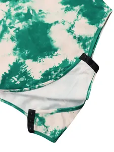 Close-up detail of a green tie-dye printed bodysuit featuring bottom snap button closure