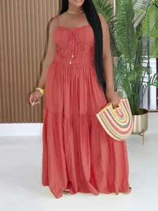 Close-up of a bohemian rust-red tiered sleeveless spaghetti strap summer maxi dress.