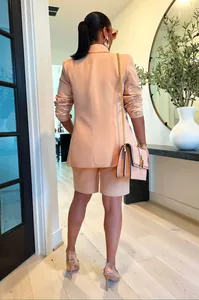 Vista trasera de un conjunto de blazer y pantalones cortos color melocotón para mujer.