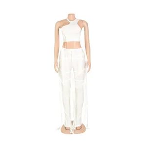 Dettaglio del set due pezzi in ecopelle bianca con cinturini a nappe e crop top sexy