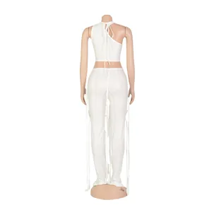 Vista posteriore di un sexy completo bianco a due pezzi con crop top halter e pantaloni in ecopelle