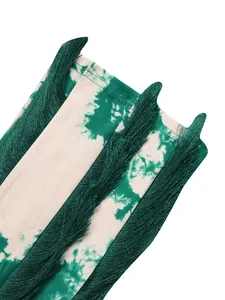 Detailed close-up of dark green tassel fringe and tie-dye print on women's summer romper