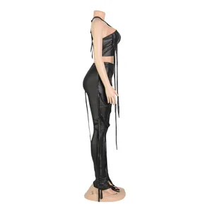 Vista laterale di un sexy set due pezzi in ecopelle nera con top all'americana e frange