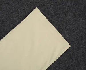 Detailed close-up of the fine stitching and linen fabric of a beige women's suit