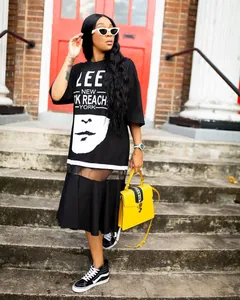 Stylish plus size black T-shirt dress featuring mesh splicing and bold graphic print detail