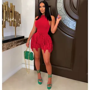 Detail shot of women's red sleeveless fringe shorts set with green accessory