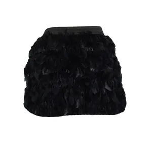 Close-up detail of black turkey feather mini skirt with fluffy texture for parties