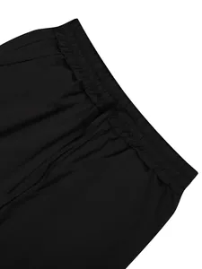 Close-up of black linen pants featuring an elastic waistband and adjustable drawstring.