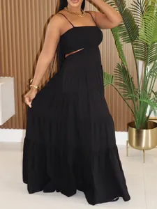 Detail showing the black sleeveless tiered maxi dress with cut-out waist design on model