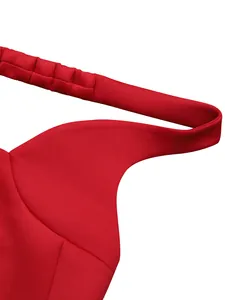 Close-up detail of red V-neck party dress with smocked shoulder strap texture.