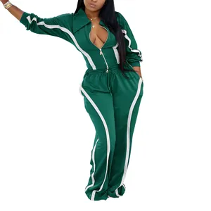 Detailed view of women's dark green two-piece tracksuit with white contrast stripe accents