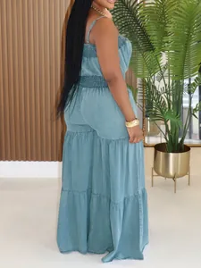 Detailed view of a blue denim jumpsuit featuring a tiered wide-leg design and smocked waist.
