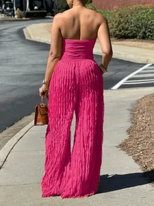 Vista posteriore completa di tuta strapless fucsia a gamba larga con texture plissettata