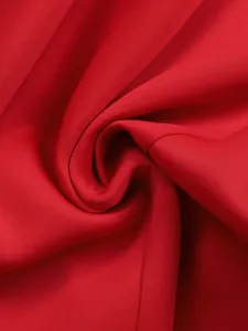 Close-up of vibrant red dress fabric showing smooth texture and elegant drape